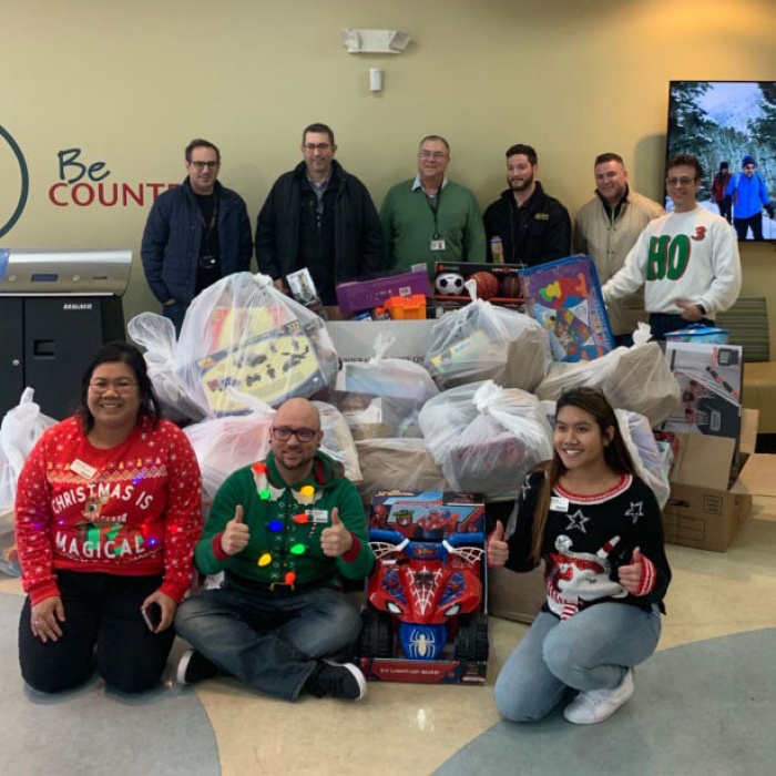 Donors and Hanscom FCU employees pose with gifts donated for Toys for Tots